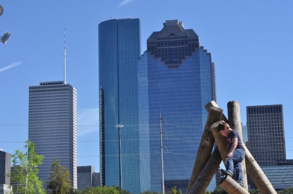 Climbing at by the Houston Skyline Fish Family Play Area Buffalo Bayou Park