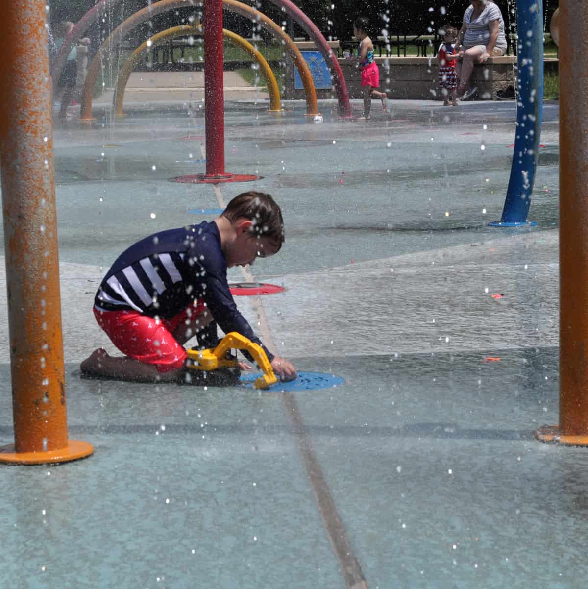 Playing with toy truck at splashpad