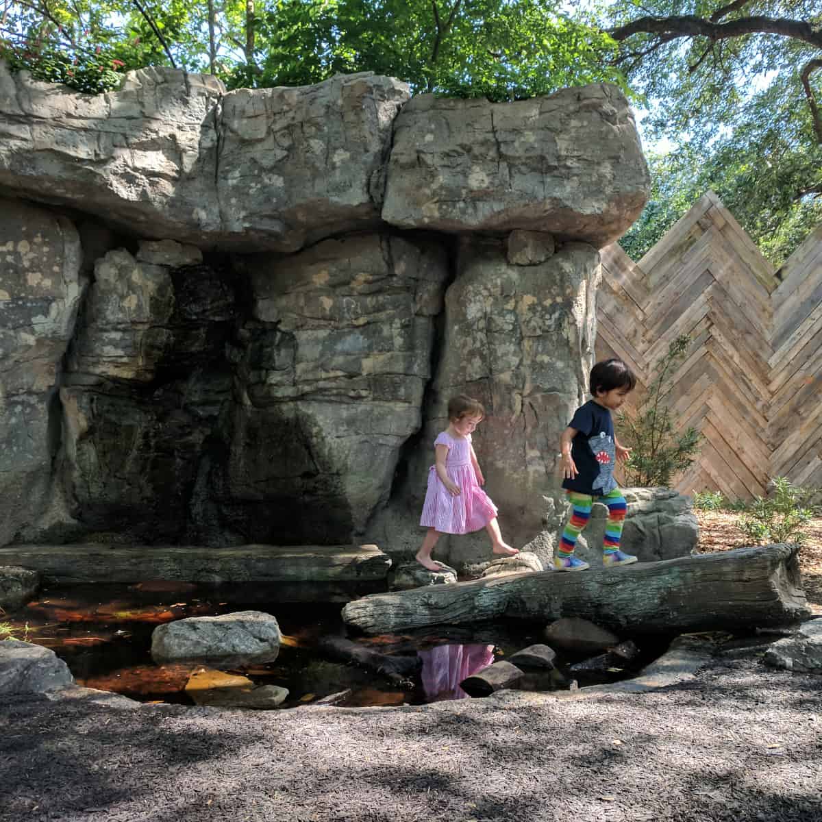 Walking on a log at Wild Nature Play Area at Houston Zoo